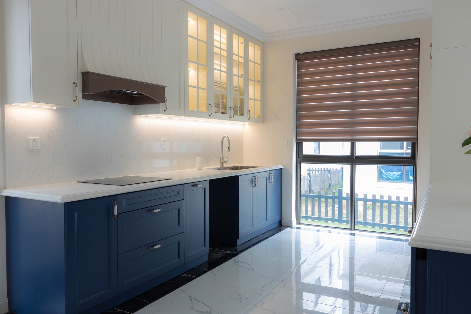A kitchen with navy blue lower cabinets and white upper cabinets