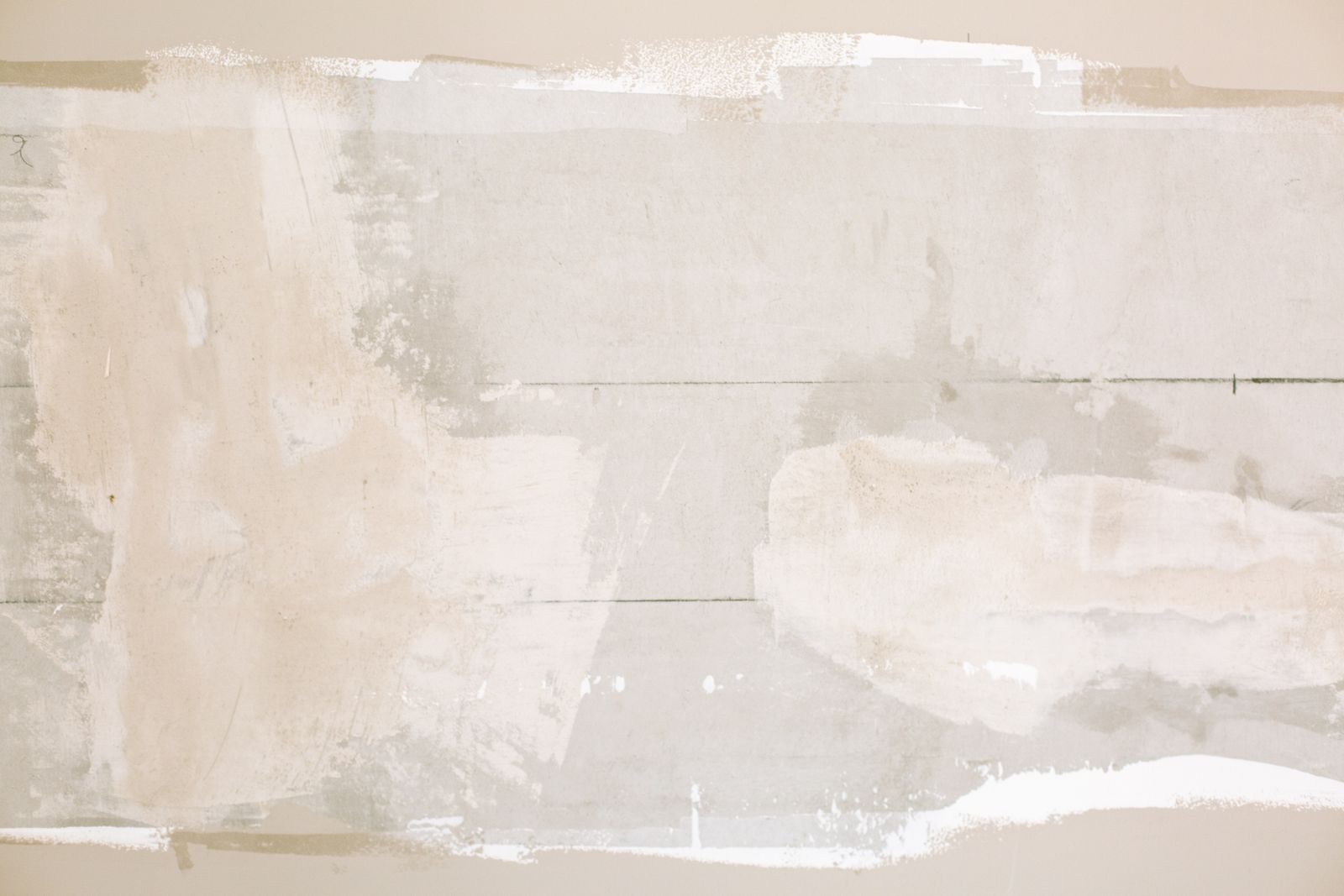 Fresh joint compound patches on a drywall wall